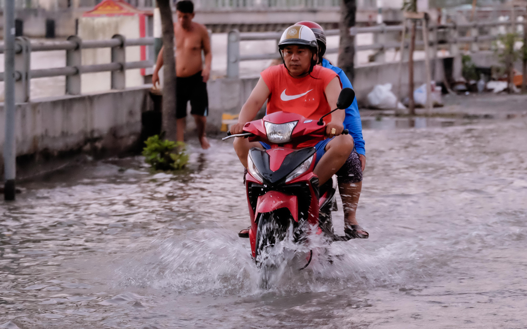 Trung tâm TP.HCM kẹt cứng đêm mùng 3 Tết- Ảnh 9. Triều cường đạt đỉnh, người dân TP.HCM bì bõm dắt xe ngày mùng 3 Tết