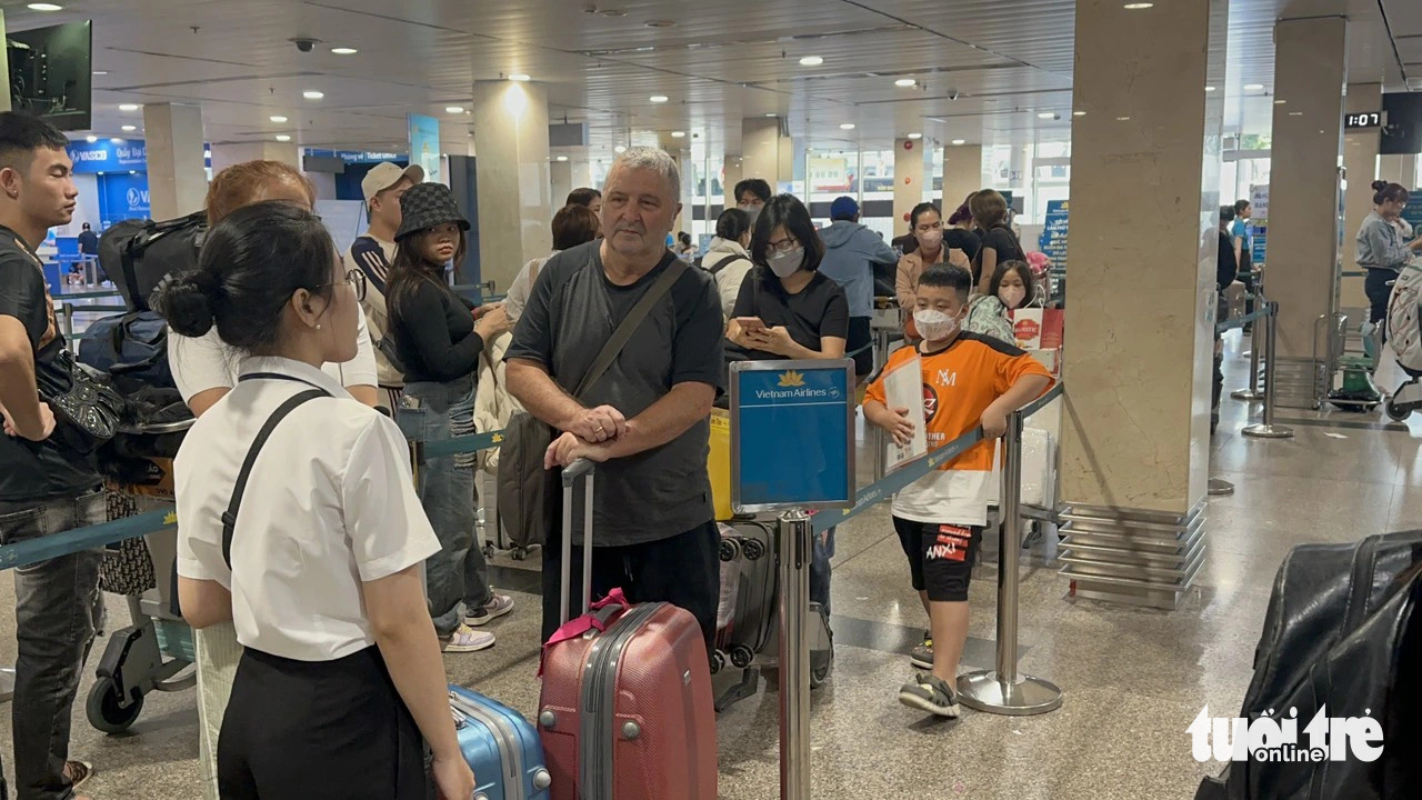 Khách trật tự xếp hàng vào khu vực check-in của hãng Vietnam Airlines - Ảnh: CÔNG TRUNG