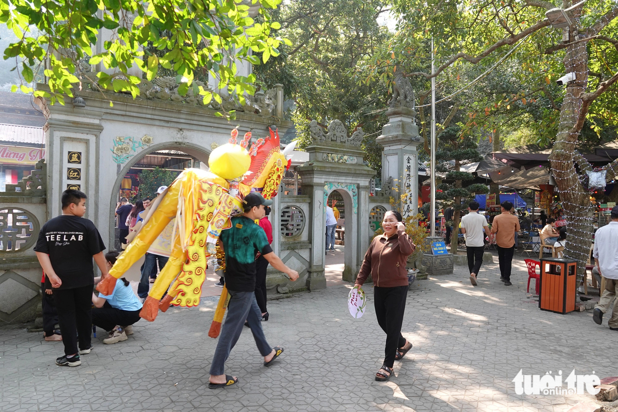 Ngựa giấy khủng sắp hàng chờ đốt tại đền Chợ Củi- Ảnh 3. Theo quan sát, vào sáng 21-2, lượng du khách đến đền chủ yếu là người dân từ các tỉnh phía Bắc. Người dân mua sắm lễ vật, trong đó có ngựa giấy để vào đền làm lễ - Ảnh: LÊ MINH