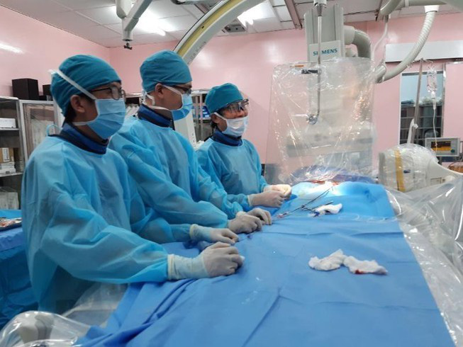 TS Đỗ Nguyên Tín cùng đồng nghiệp trong một ca can thiệp tim cho bệnh nhi - Ảnh: Bác sĩ cung cấp