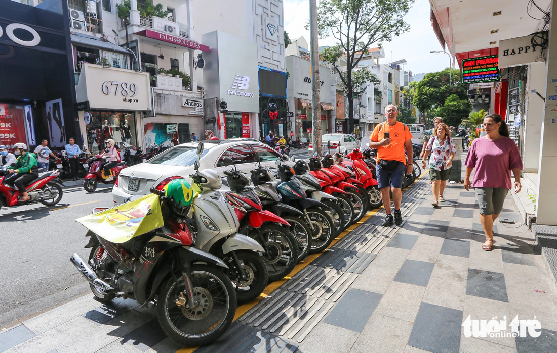 Xe máy ở đoạn vỉa hè đường Nguyễn Trãi (phường Bến Thành, quận 1, TP.HCM) được người dân sắp xếp gọn gàng ở khu vực để xe miễn phí - Ảnh: CHÂU TUẤN