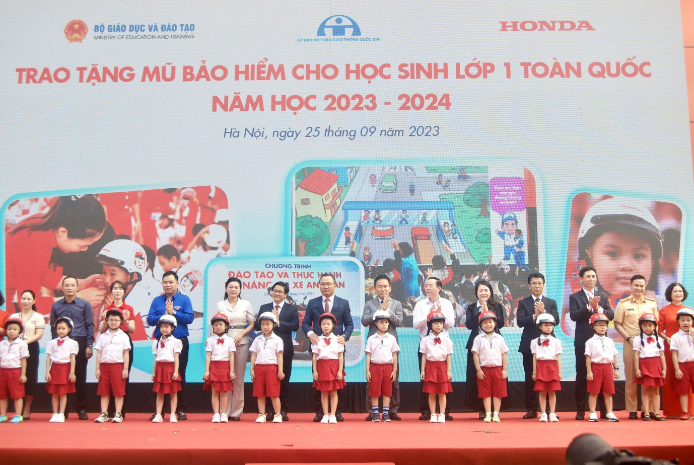 Các đại biểu trao tặng mũ bảo hiểm cho các em học sinh lớp 1 Trường tiểu học Phú Đô