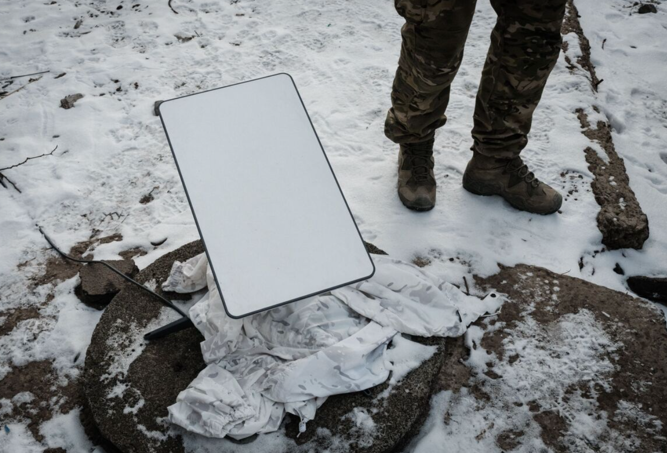 Một quân nhân Ukraine đứng cạnh ăng ten Starlink - Ảnh: GETTY IMAGES