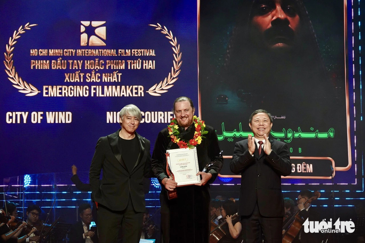 Der Preis für den besten Debüt- oder Zweitfilm wurde von Duong Anh Duc, dem stellvertretenden Vorsitzenden des Volkskomitees von Ho-Chi-Minh-Stadt, und Tom Cross, einem Oscar-prämierten Filmeditor, überreicht. Regisseur Aaron Toronton nahm den Preis in seinem Namen entgegen – Foto: T.T.D. Giải Phim đầu tay hoặc phim thứ hai xuất sắc do ông Dương Anh Đức, phó chủ tịch UBND TP.HCM và ông Tom Cross - nhà dựng phim đoạt giải Oscar, cùng trao. Đạo diễn Aaron Toronton nhận thay - Ảnh: T.T.D.