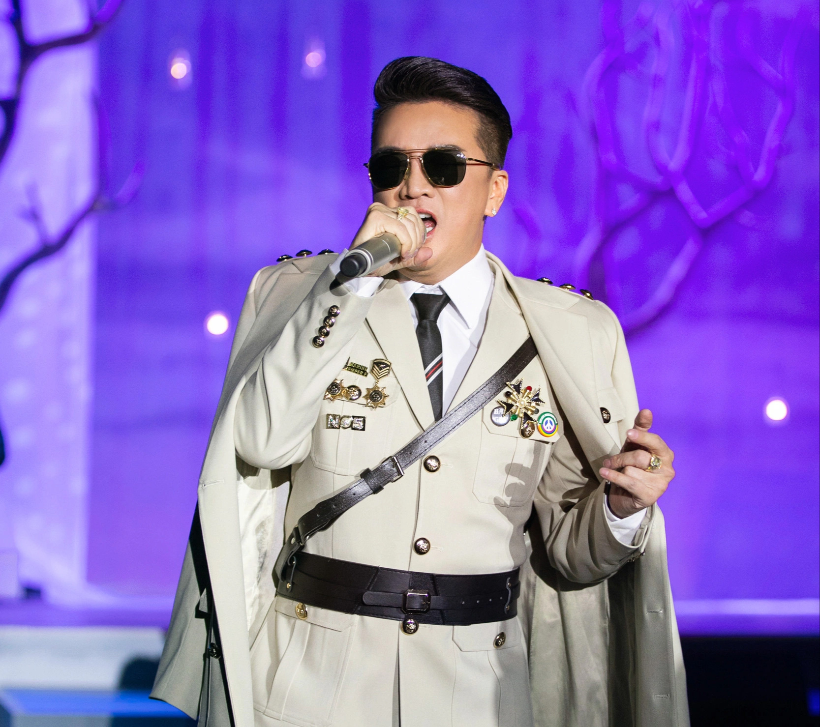 ປ້າຍຖືກປັກໃສ່ຊຸດອາພອນຂອງ Dam Vinh Hung ໃນລາຍການສະແດງສົດ The Day You Lighted the Stars - ພາບ: GLASSES TEAM Những huy hiệu cài trên trang phục Đàm Vĩnh Hưng diễn trong live show Ngày em thắp sao trời - Ảnh: KIẾNG CẬN TEAM