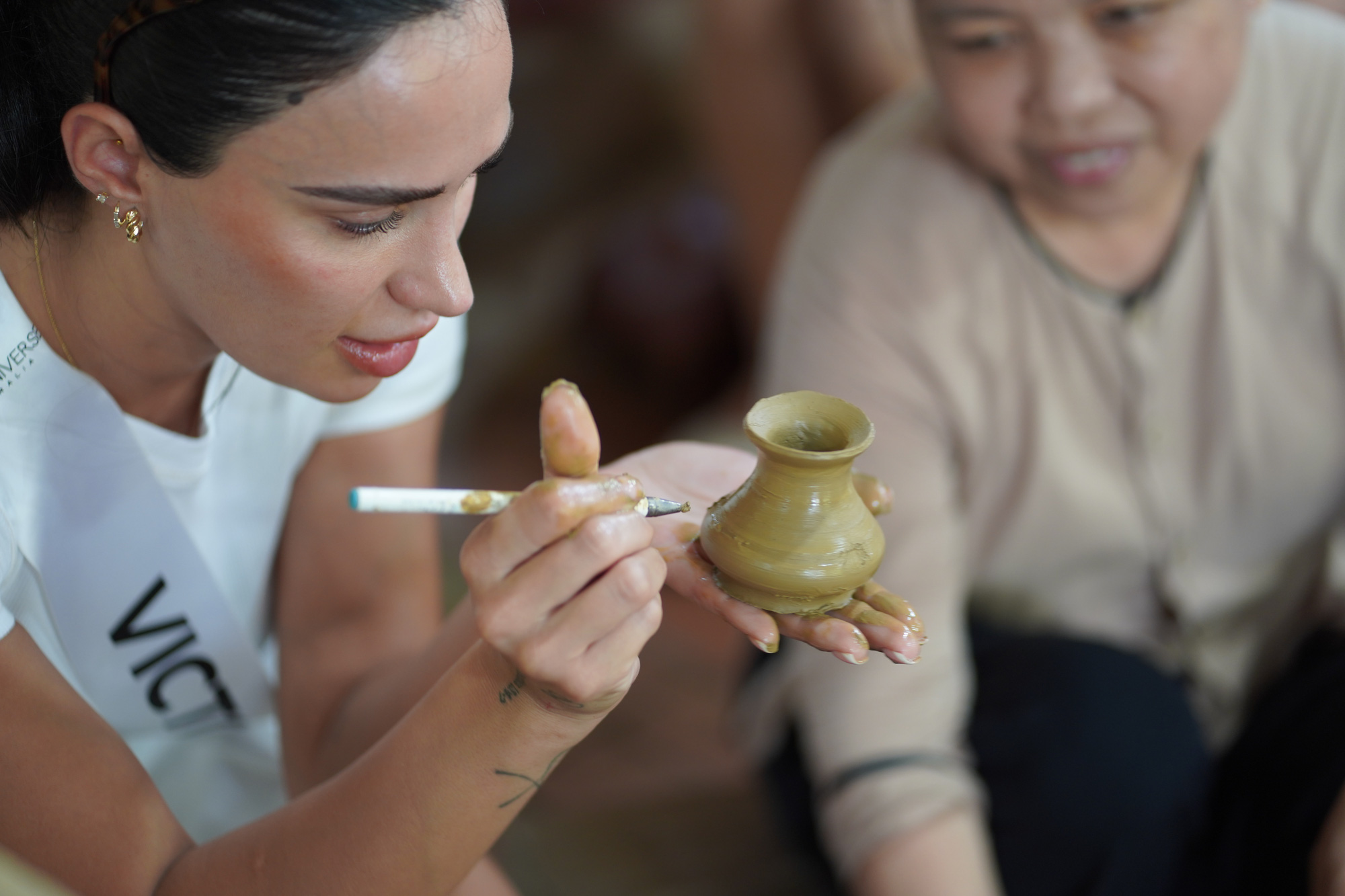 Rainhas da beleza australianas caminham e fazem cerâmica, atraindo atenção em Hoi An - Foto 1. Người đẹp Úc trải nghiệm làng gốm Thanh Hà - Ảnh: BẢO CHÂU
