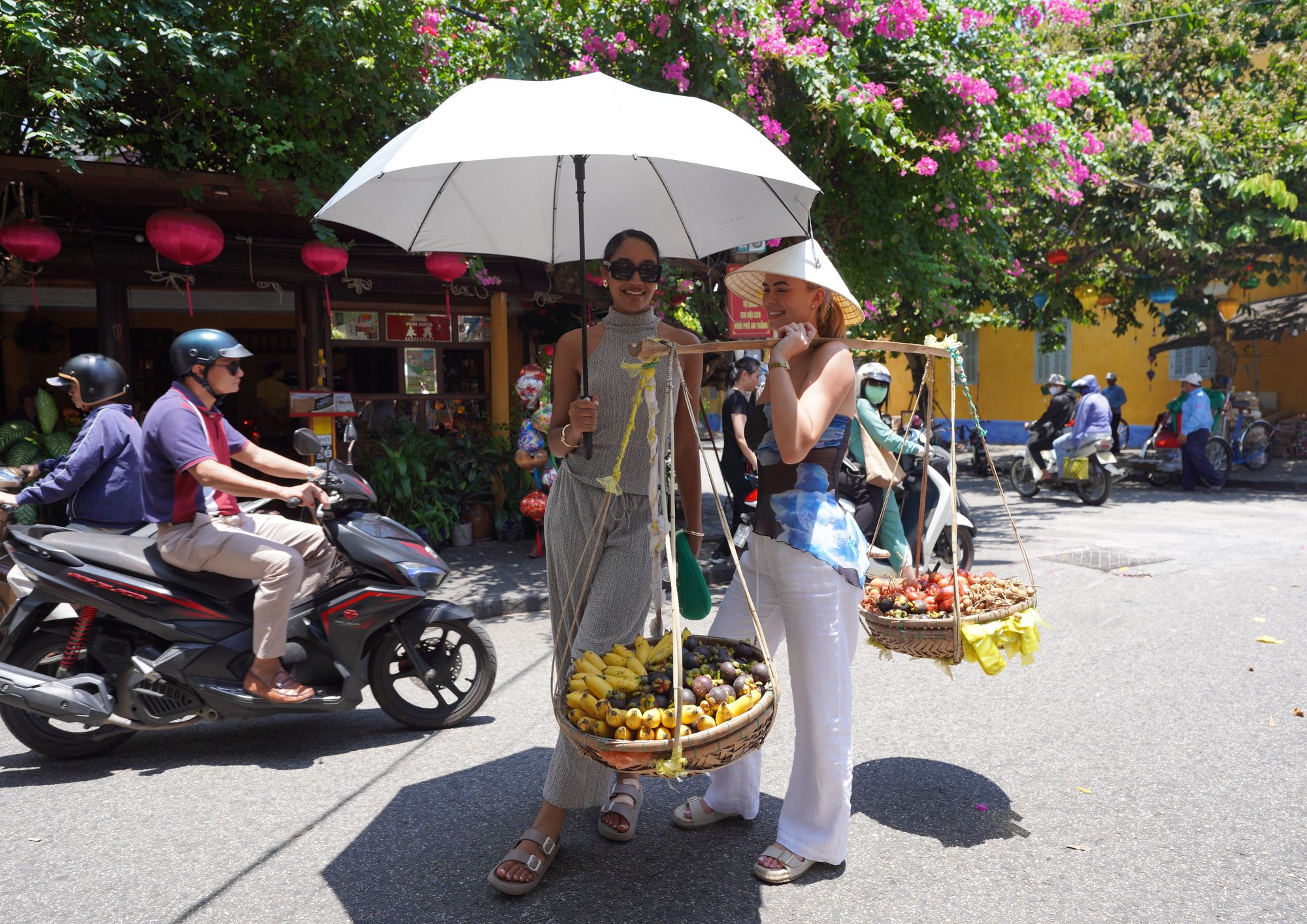 Rainhas da beleza australianas caminham e fazem cerâmica, atraindo atenção em Hoi An - Foto 2. Các thí sinh đi bộ và trải nghiệm hàng rong ở phố cổ - Ảnh: BẢO CHÂU