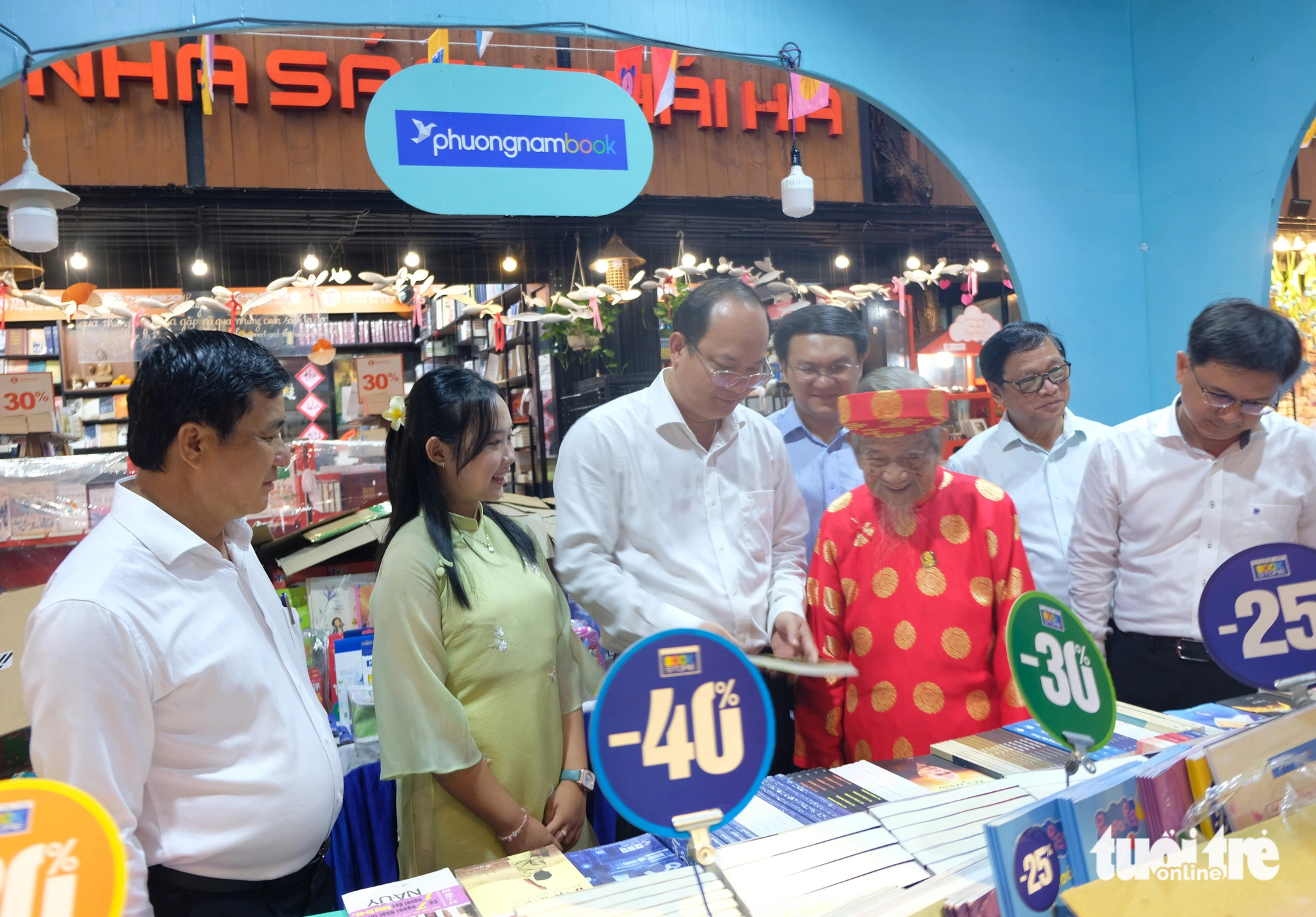 Phó bí thư thường trực Thành ủy TP.HCM Nguyễn Hồ Hải (thứ 3, từ trái qua), cụ Nguyễn Đình Tư và một số lãnh đạo tham quan hội sách. Trời mưa lớn thời điểm khai mạc nên khách tham quan không đông - Ảnh: LINH ĐOAN