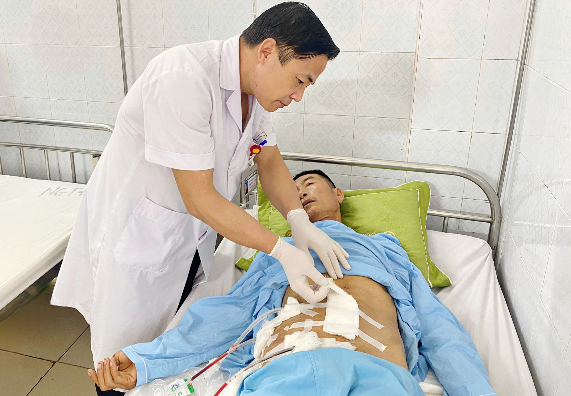 Chiếc xà beng dài hơn 1m đâm xuyên thành bụng người đàn ông 61 tuổi- Ảnh 1. Bác sĩ kiểm tra vết mổ của bệnh nhân N.V.B. - Ảnh: Bệnh viện Đa khoa tỉnh Thanh Hóa cung cấp