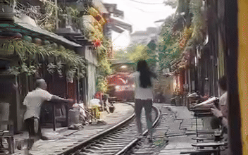 Cà phê đường tàu: Không để hành vi bất thường của cô gái làm 'chết' oan sản phẩm du lịch độc đáo- Ảnh 5. Tàu hỏa tới, cô gái vẫn lao ra đường ray tạo dáng ở phố cà phê đường tàu