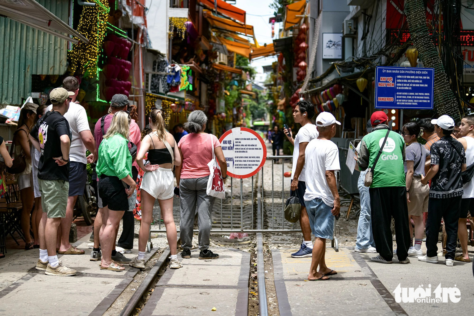 जब सुरक्षा गार्डों ने घोषणा की कि उन्हें रेलवे क्षेत्र में प्रवेश की अनुमति नहीं है, तो कई पर्यटक अफसोस के साथ वापस चले गए - फोटो: नाम ट्रान Nhiều du khách tiếc nuối ra về khi nhân viên bảo vệ thông báo không được vào khu vực đường tàu - Ảnh: NAM TRẦN
