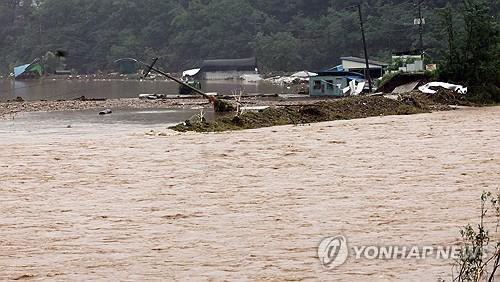 Nước dâng cao tại một con suối ở tỉnh Wanja sau khi mưa lớn trút xuống vào ngày 10-7 - Ảnh: YONHAP