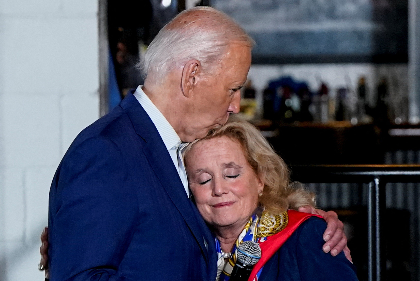 Tổng thống Mỹ Joe Biden hôn hạ nghị sĩ Debbie Dingell khi đến thăm bang Michigan ngày 12-7 - Ảnh: REUTERS