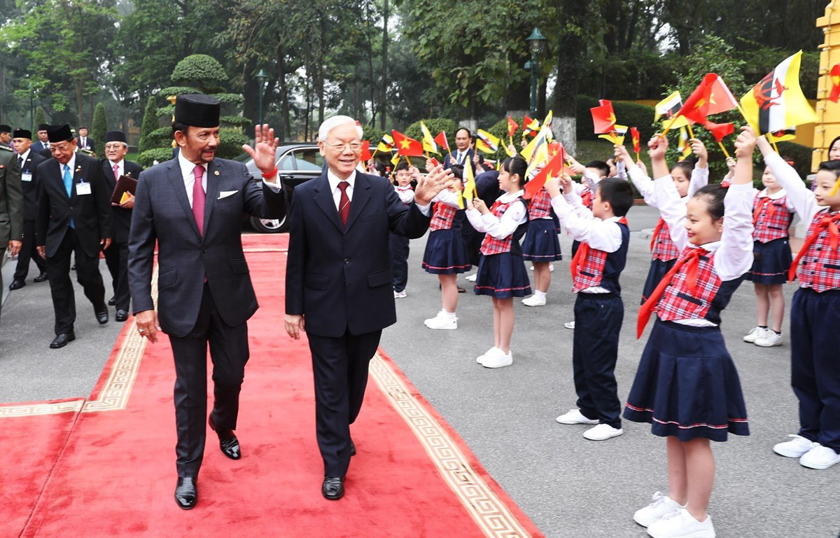 Quốc vương Brunei Hassanal Bolkiah và Tổng bí thư, Chủ tịch nước Nguyễn Phú Trọng vẫy tay chào các cháu thiếu nhi khi nhà lãnh đạo Brunei thăm Việt Nam năm 2019 - Ảnh: TTXVN