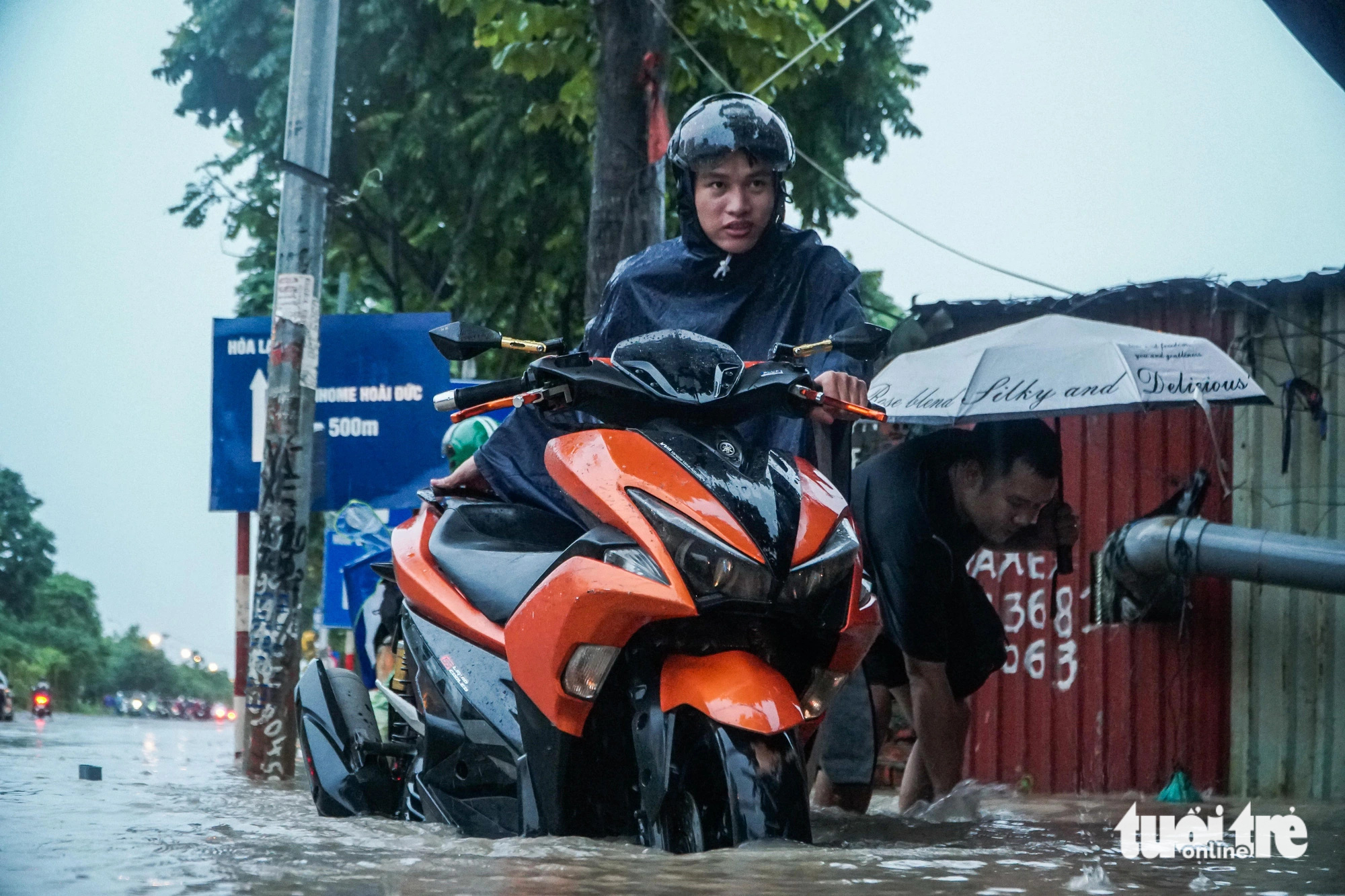 Nam thanh niên cố đi qua đoạn đường ngập sâu khiến xe bị chết máy - Ảnh: PHẠM TUẤN