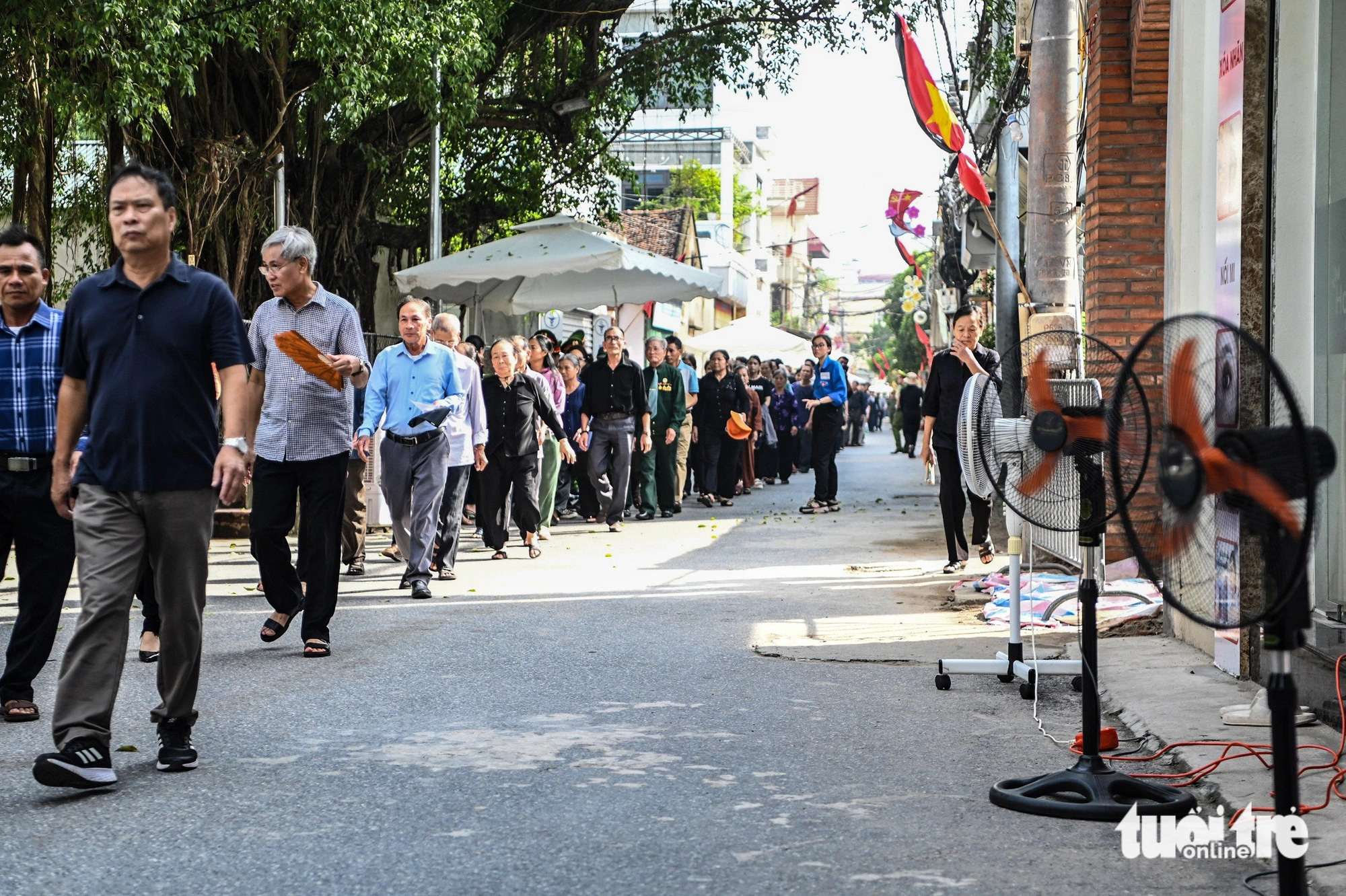 Folk satte upp fläktar på gatan och gjorde lemonad till besökare hos generalsekreterare Nguyen Phu Trong - Foto 2. Người dân xếp quạt cây ra đường, pha nước chanh cho người đến viếng Tổng Bí thư Nguyễn Phú Trọng- Ảnh 2.