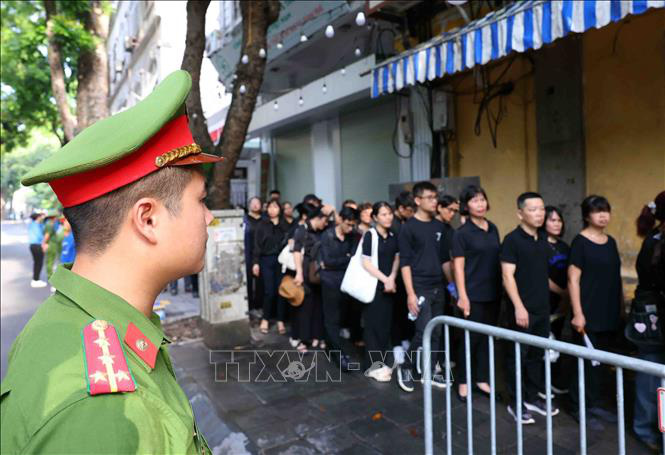 Cán bộ, chiến sĩ Công an thành phố Hà Nội làm nhiệm vụ trên phố Nguyễn Công Trứ, giúp người dân vào Nhà tang lễ Quốc gia sáng 26-7