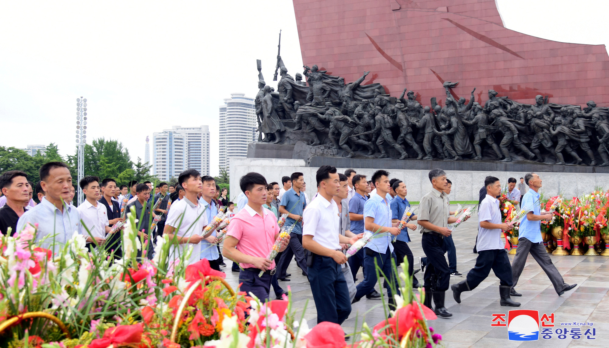 Người dân Triều Tiên đến đặt hoa tại tượng đài hai cố lãnh đạo Kim Nhật Thành và Kim Jong Il trong ngày kỷ niệm 71 năm đình chiến - Ảnh: REUTERS