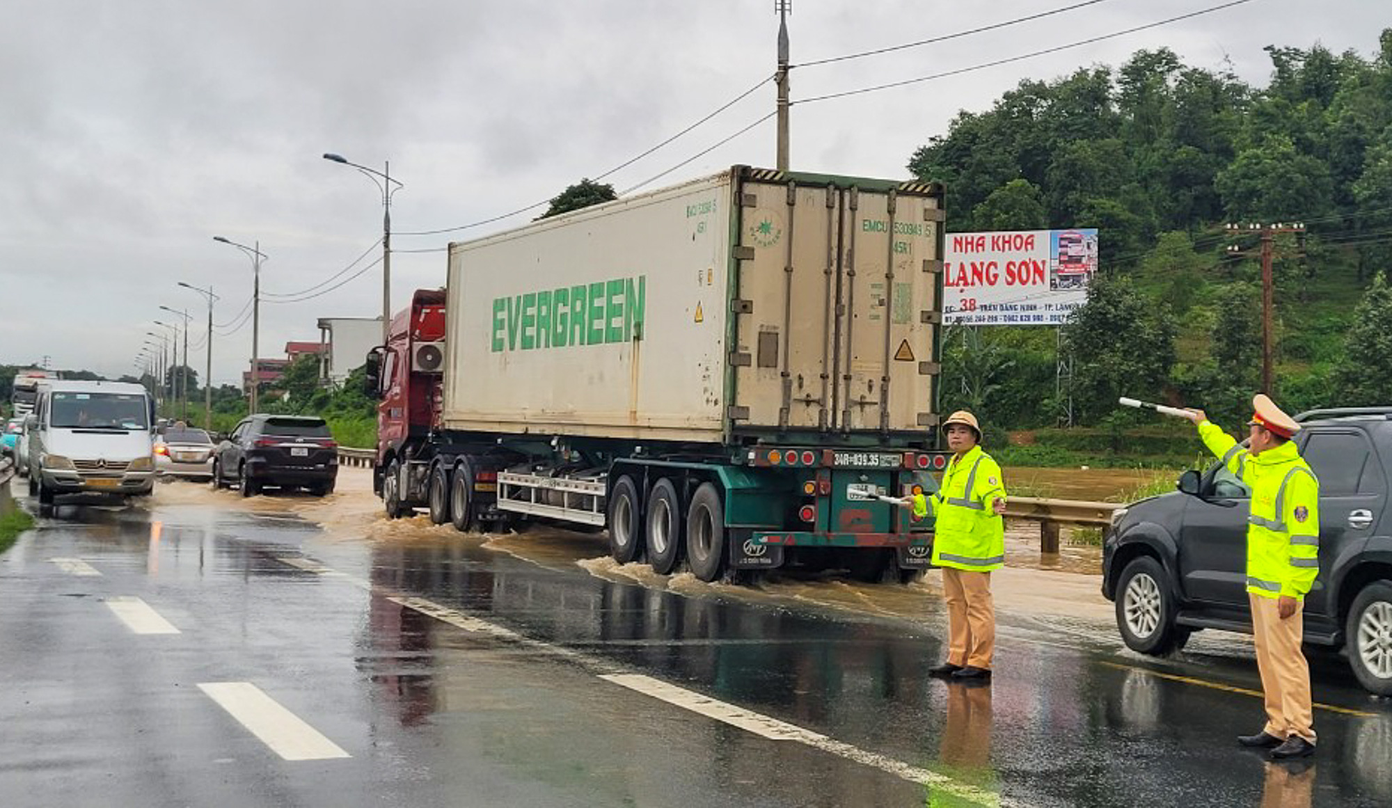 Cảnh sát giao thông điều tiết xe qua các đoạn trũng ngập nước sau cơn mưa lớn chiều 30-7 - Ảnh: Công an Lạng Sơn