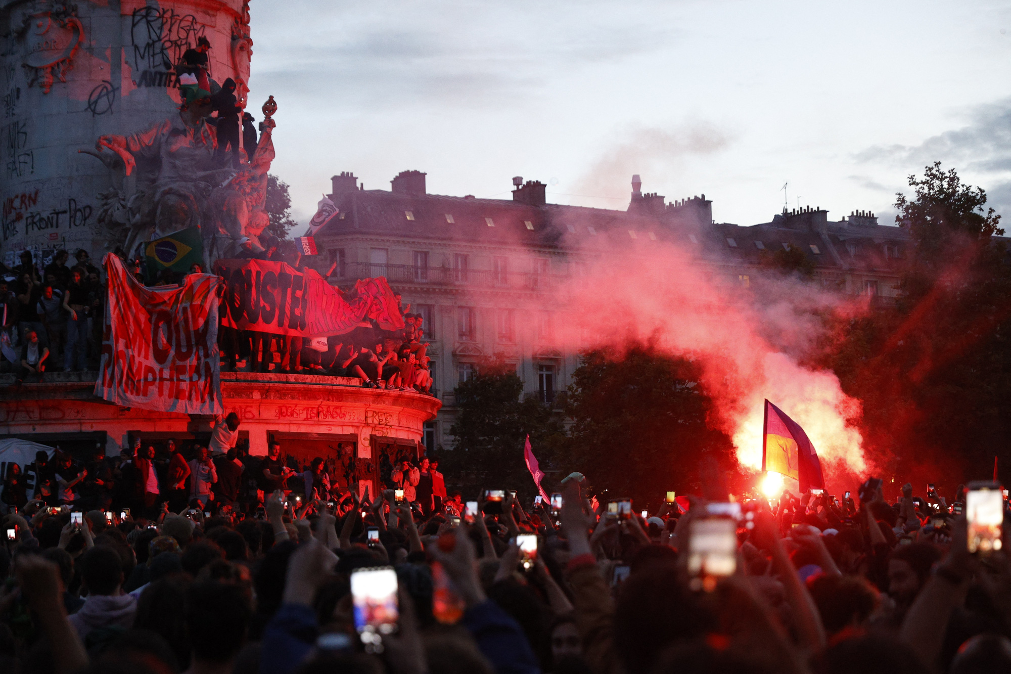 Thủ đô Paris hoa lệ rực sáng bởi lửa, bom khói, bom xăng và pháo sáng từ đám đông biểu tình sau khi có kết quả kiểm phiếu sơ bộ vòng hai cuộc bầu cử Quốc hội Pháp vào chiều tối 7-7 - Ảnh: REUTERS