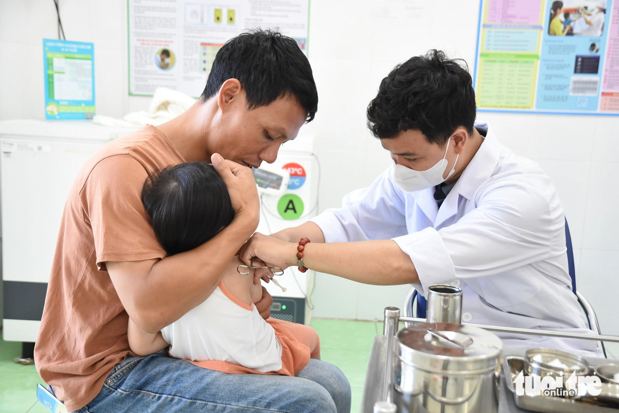 Lo dịch sởi, phụ huynh TP.HCM gấp rút đưa con đi tiêm vắc xin- Ảnh 1. Phụ huynh đưa con đi tiêm vắc xin phòng bệnh tại Trạm y tế phường Phước Long A (TP Thủ Đức) - Ảnh: THU HIẾN