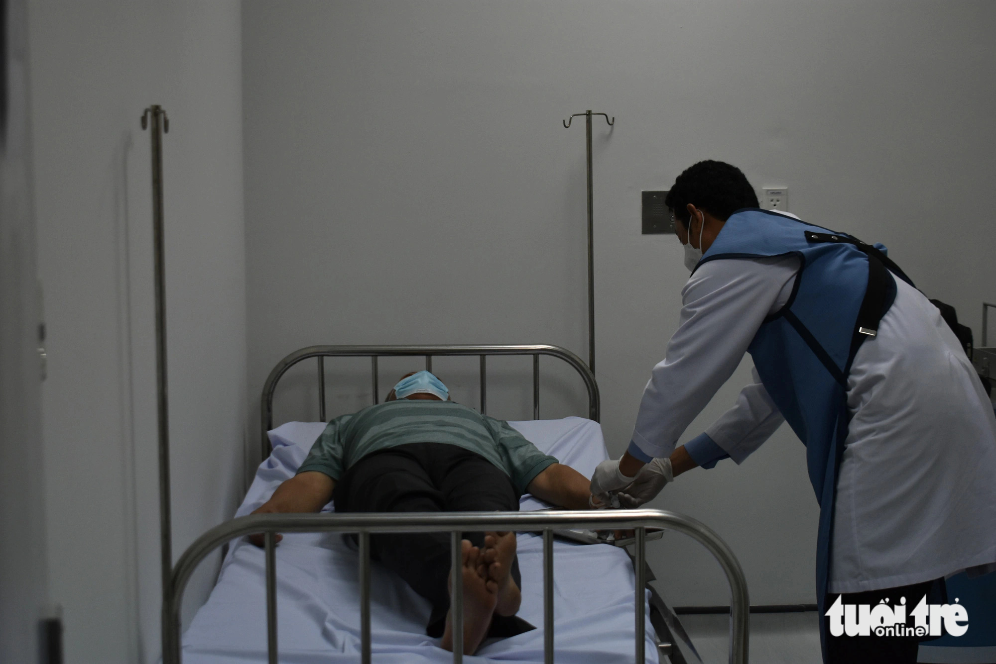 Bác sĩ đến từ Bệnh viện Chợ Rẫy tiêm thuốc phóng xạ vào bệnh nhân điều trị ung thư - Ảnh: BỬU ĐẤU