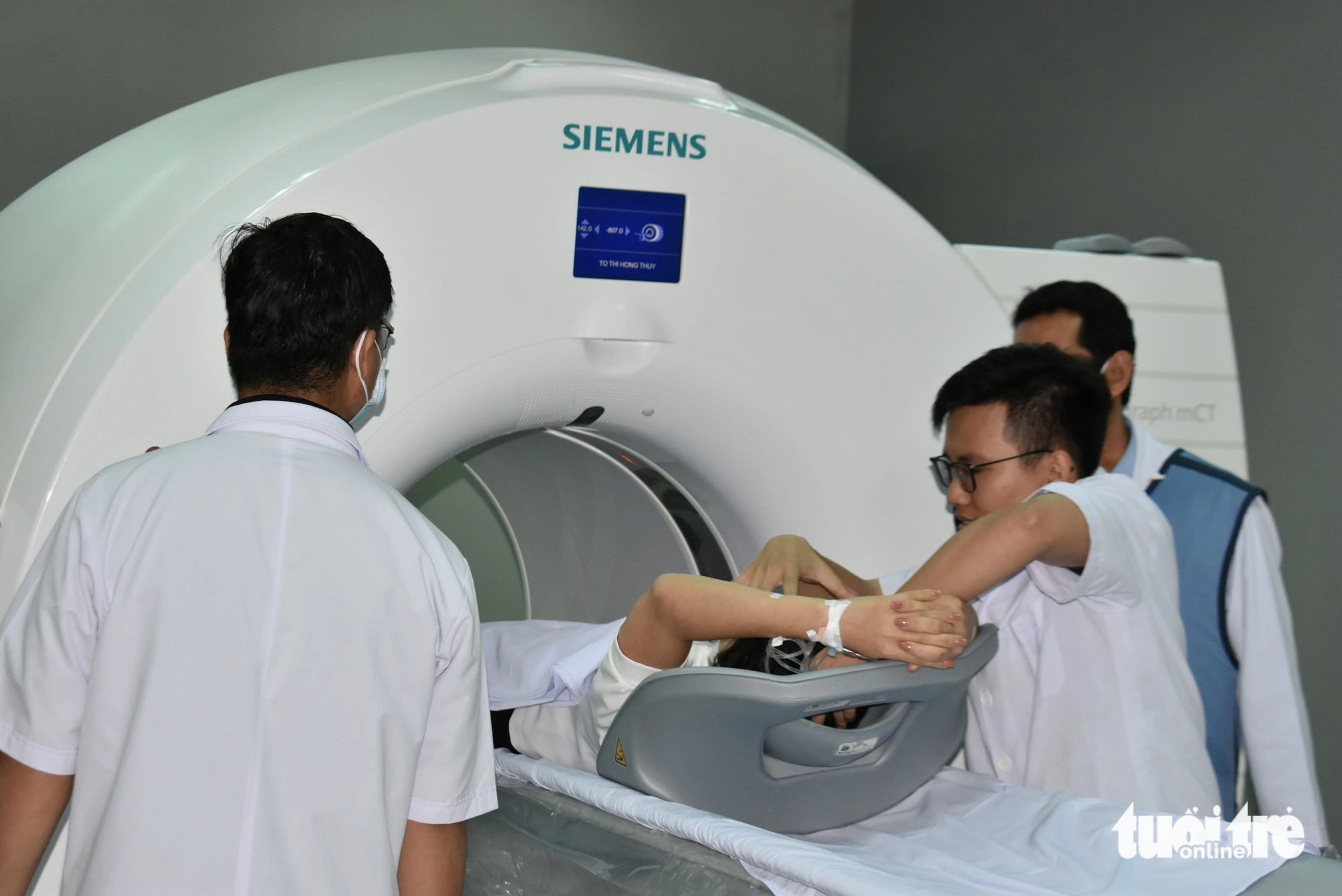 Các bác sĩ đưa bệnh nhân đầu tiên vào máy chụp PET-CT để chẩn đoán, đánh giá chính xác giai đoạn ung thư của bệnh nhân - Ảnh: BỬU ĐẤU