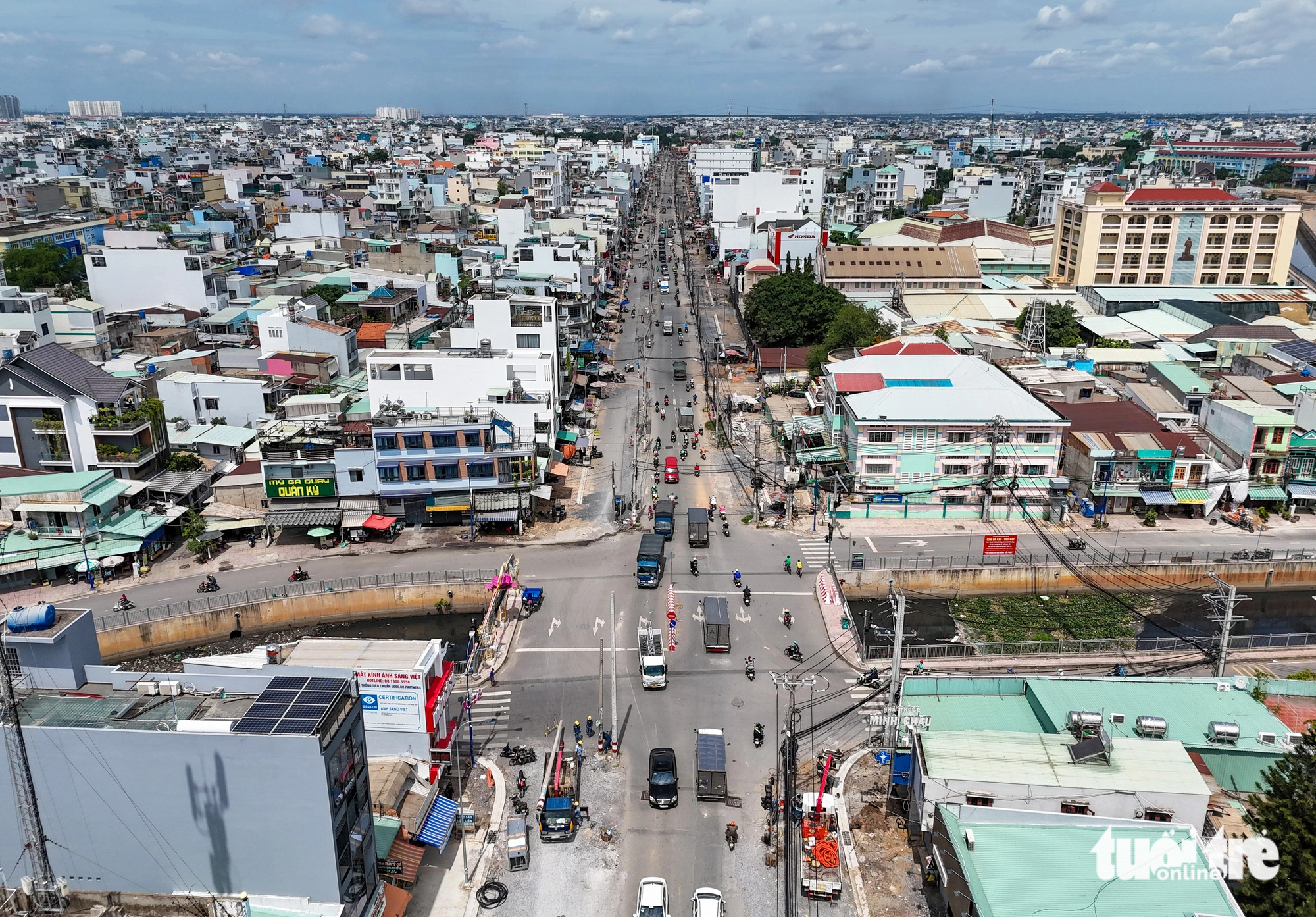 Các đơn vị di dời cột đèn tín hiệu giao thông tại giao lộ Tân Kỳ Tân Quý - kênh Nước Đen (quận Bình Tân, TP.HCM) để có mặt bằng hoàn thành dự án mở rộng đường. Ghi nhận vào ngày 29-7 - Ảnh: CHÂU TUẤN