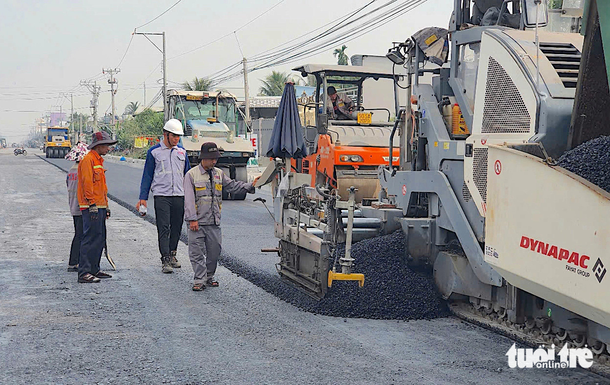 Bắt đầu thảm nhựa đường dẫn lên cầu Rạch Miễu 2 phía bờ Tiền Giang - Ảnh 1.