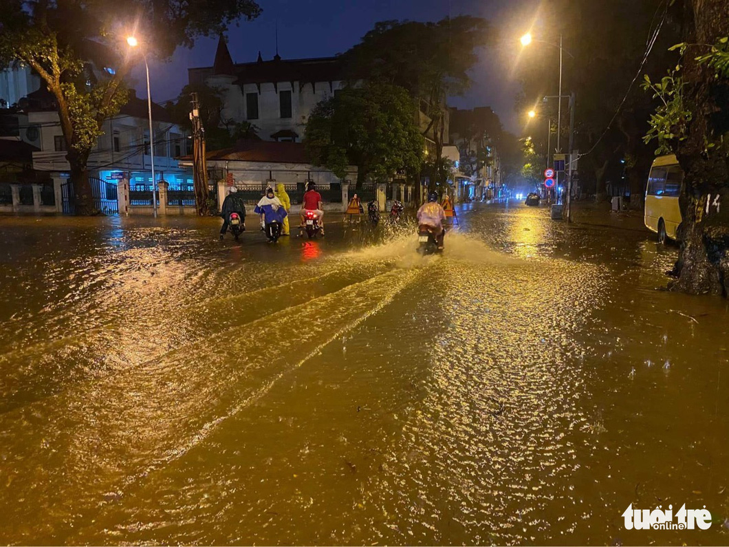 Hà Nội mưa chưa đầy 1 giờ, nhiều tuyến phố thành sông, nước tràn vào nhà dân - Ảnh 5.