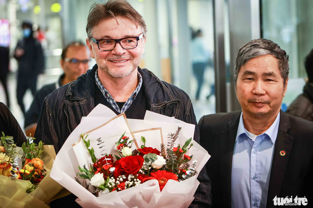 Tổng thư ký VFF Dương Nghiệp Khôi tặng hoa cho HLV Philippe Troussier khi ông đến sân bay Quốc tế Nội Bài - Ảnh: NGUYỄN KHÁNH 