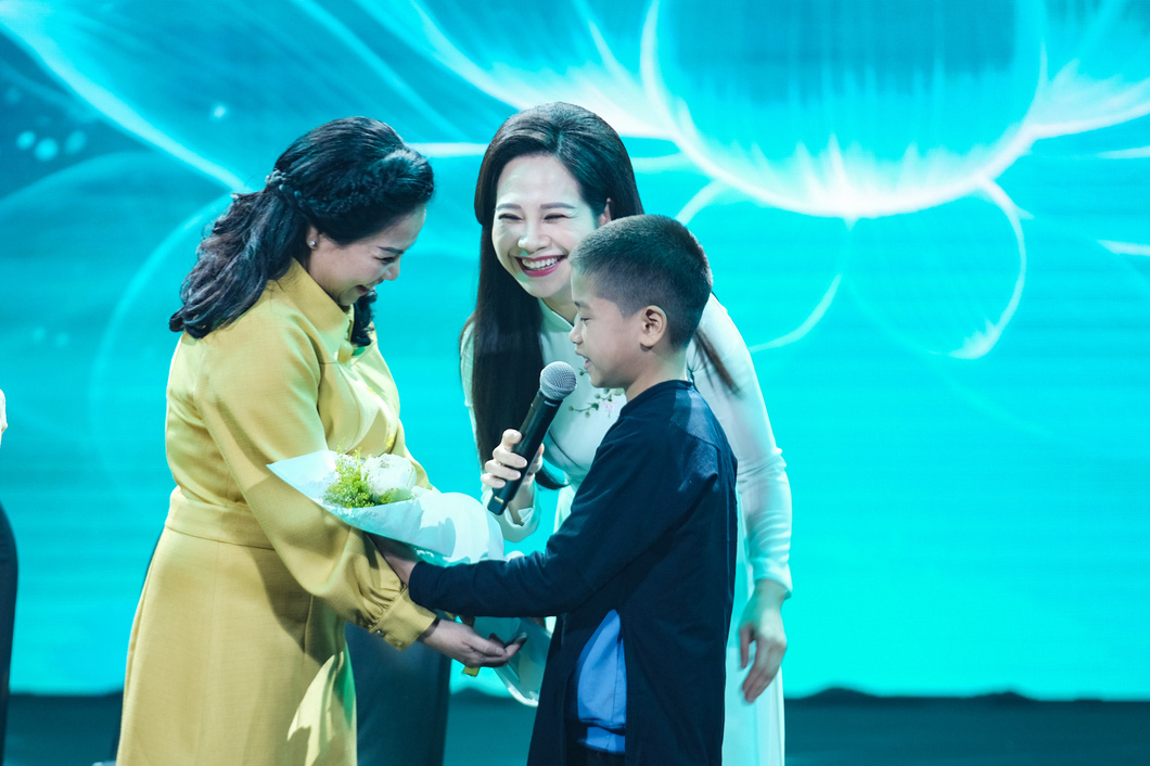 Bé Linh Ngọc Hiệu (12 tuổi) tặng hoa và nói lời cảm ơn đối với chủ tịch quỹ - Ảnh: QUỲNH NHƯ