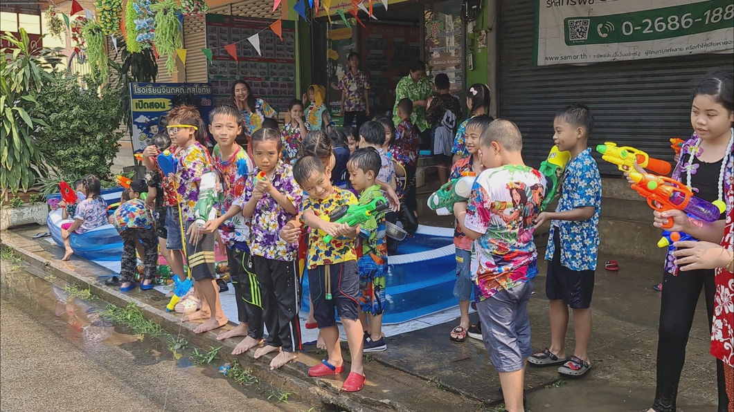 Những em bé ở tỉnh Sukhothai, miền trung đông Thái Lan mặc áo sơ mi hoa đậm chất mùa hè, tay cầm súng nước để sẵn sàng cho một "cuộc chiến khốc liệt" - Ảnh: NATION THAILAND