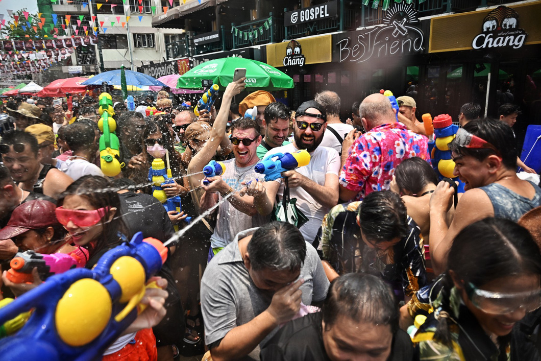 Những du khách nước ngoài hào hứng "chiến đấu" hết mình tại đường Khaosan, trung tâm thủ đô Bangkok trong ngày đầu tiên của Tết Songkran 2023 - Ảnh: AFP