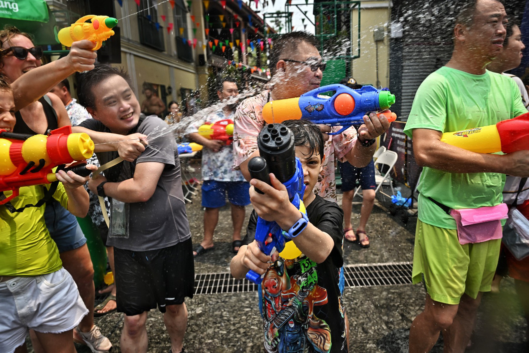 Bất kể người lớn hay trẻ nhỏ, đàn ông hay phụ nữ, bất kể quốc tịch, màu da, tất cả mọi người đều cùng nhau hòa vào làn nước mát dưới cái nóng gay gắt của mùa hè Bangkok - Ảnh: AFP
