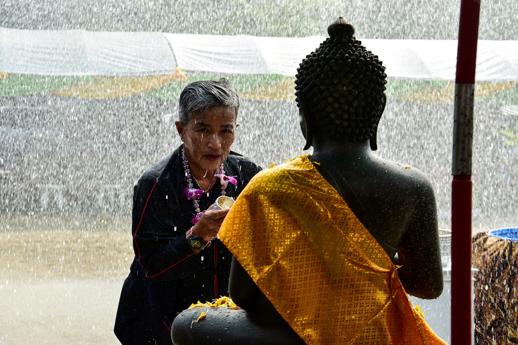 Một người dân tại tỉnh Narathiwat, miền nam Thái Lan đang thực hiện nghi thức Tắm Phật, một phần không thể thiếu trong Tết Songkran - Ảnh: AFP