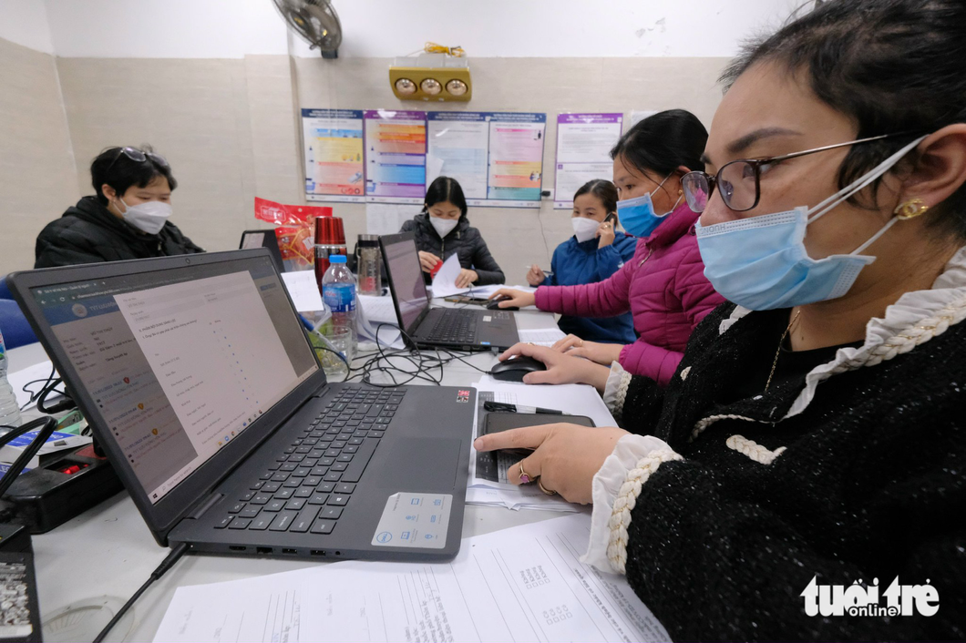 Nhân viên y tế tại Trạm y tế nhập liệu báo cáo ca mắc COVID-19 tại Hà Nội - Ảnh: NAM TRẦN