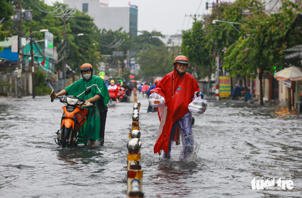 Mưa lớn giữa trưa ở TP.HCM, nhiều đường thành sông - Ảnh 1. Mưa lớn giữa trưa ở TP.HCM, nhiều đường thành sông - Ảnh 1.