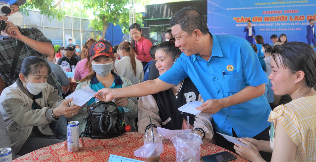 Phó chủ tịch thường trực Liên đoàn Lao động TP.HCM Trần Đoàn Trung tặng quà cho người lao động - Ảnh: CÔNG TRIỆU