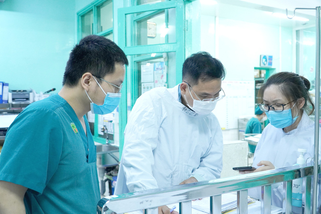 Bác sĩ khoa bệnh nhiệt đới Bệnh viện Chợ Rẫy phối hợp bác sĩ Bệnh viện Nhi Đồng 2 xem hồ sơ sức khỏe của ba bệnh nhi nghi ngộ độc botulinum do ăn chả lụa bán dạo - Ảnh: BVCR