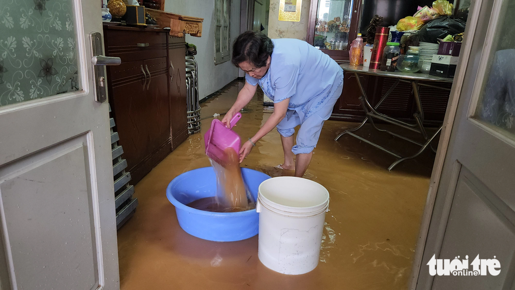 Người dân dọn nước sau trận mưa - Ảnh: M.V