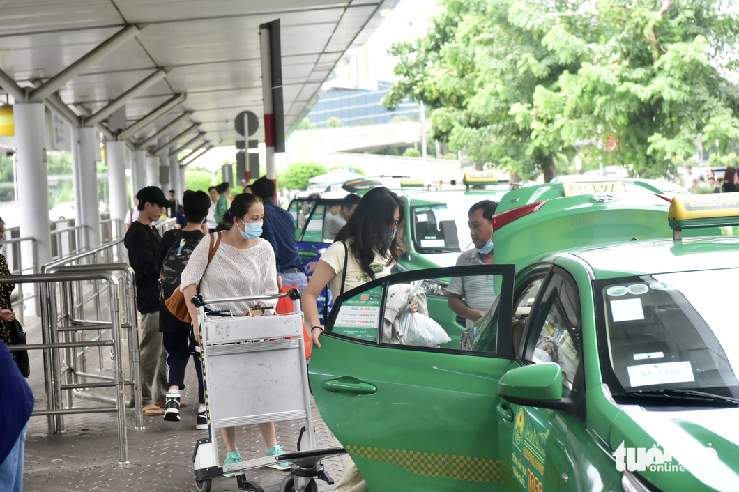 Nhằm ngăn chặn nạn gian lận cước taxi, các đơn vị quản lý cần kiểm tra chặt và xử lý mạnh để răn đe. Trong ảnh: hành khách đón taxi tại sân bay Tân Sơn Nhất (TP.HCM) chiều 24-6 - Ảnh: T.T.D.