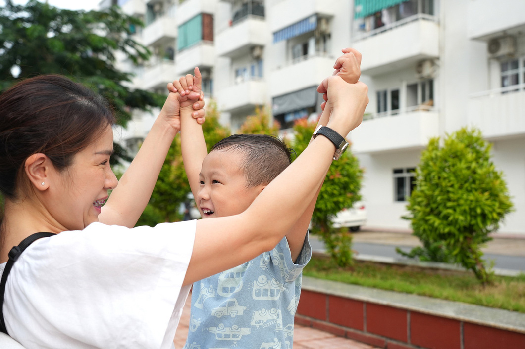Hai mẹ con chị Nguyễn Thị Thanh Trâm cùng vui đùa trong khu công viên nội bộ của chung cư Lê Thành (quận Bình Tân, TP.HCM) - Ảnh: HỮU HẠNH