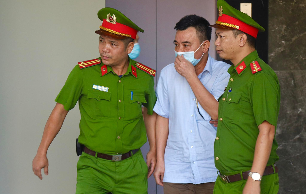 Cựu phó giám đốc Công an Hà Nội được dẫn giải đến phiên tòa xử vụ chuyến bay giải cứu - Ảnh: DANH TRỌNG