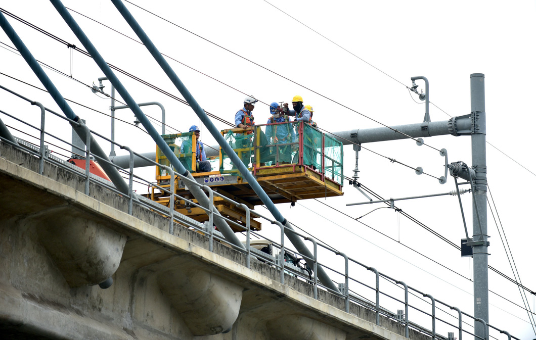 Công nhân, nhân viên kỹ thuật gia cố hệ thống điện tuyến metro số 1 (Bến Thành - Suối Tiên) tại khu vực ga Tân Cảng chiều 20-7 - Ảnh: T.T.D.