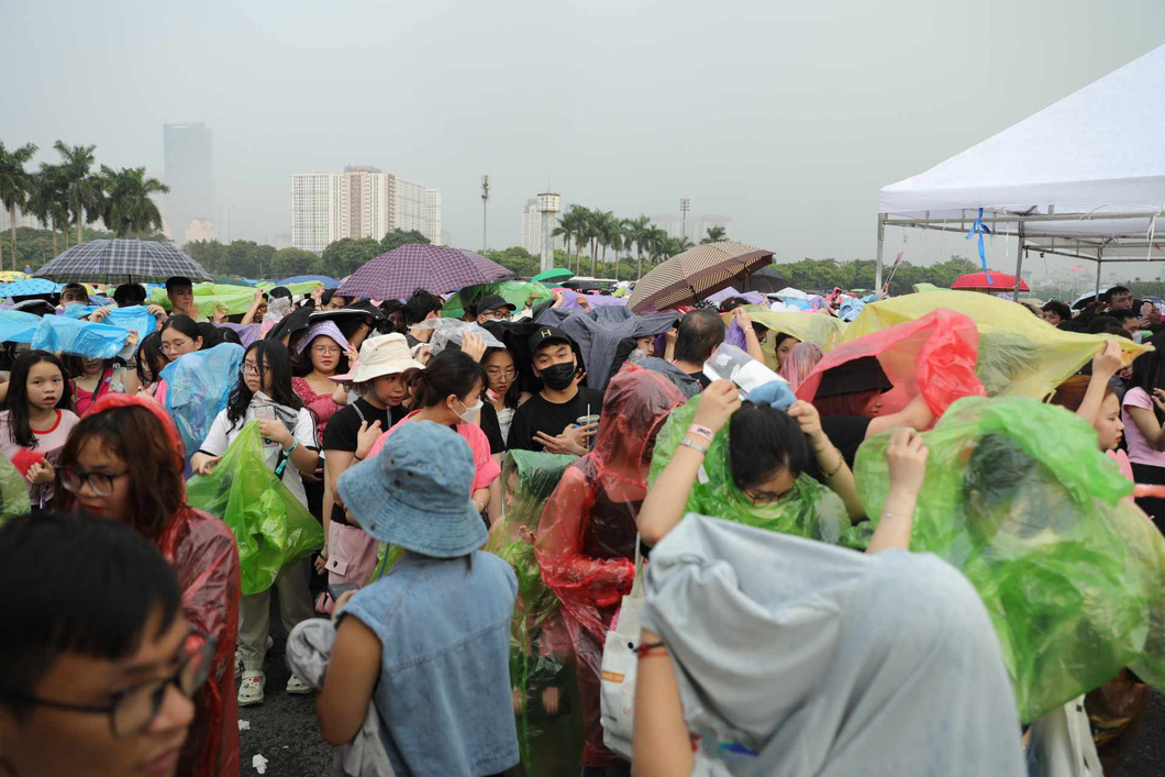 17h35 trời bất chợt đổ mưa trong khi khán giả chưa vào sân. Nhiều người chấp nhận mua áo mưa với giá 30.000 đồng/ chiếc