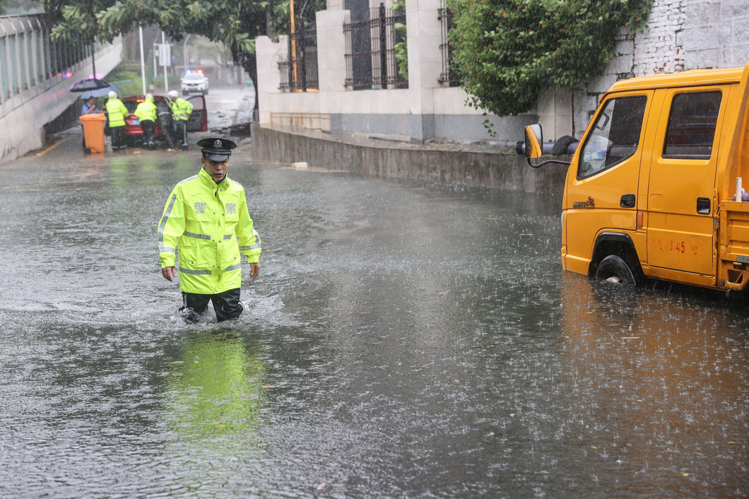 Cảnh sát di chuyển trên đường ngập nước tại thành phố Hạ Môn, tỉnh Phúc Kiến - Ảnh: AFP