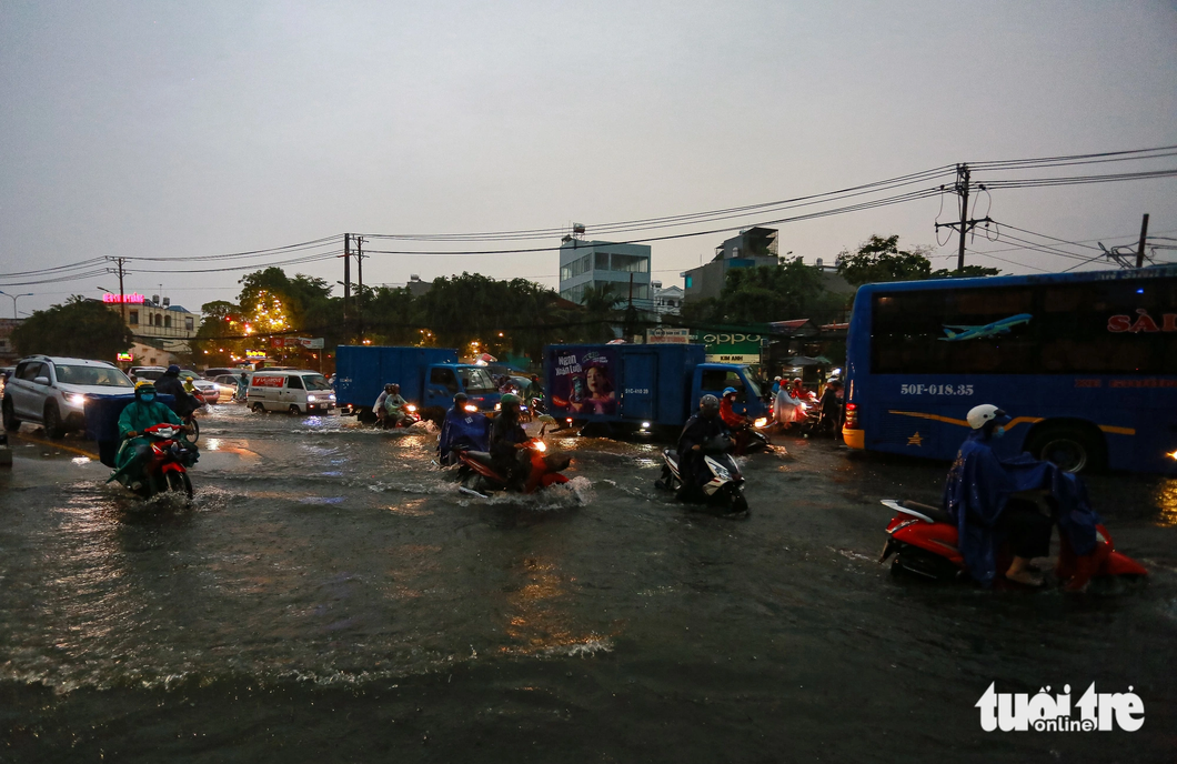 Đến 19h cùng ngày, tình trạng ngập nước trên quốc lộ 13 vẫn chưa có dấu hiệu giảm - Ảnh: CHÂU TUẤN