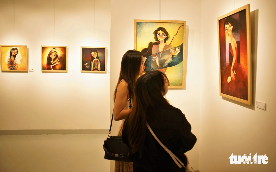 Người xem thưởng lãm "Những nỗi buồn đẹp" của họa sĩ Hồng Ngọc tại triển lãm - Ảnh: HUỲNH VY