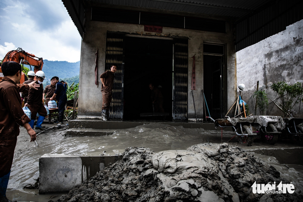 Nhân viên Công ty cổ phần đồng Tả Phời thu dọn bùn thải tại một hộ dân ở thôn Phời 3